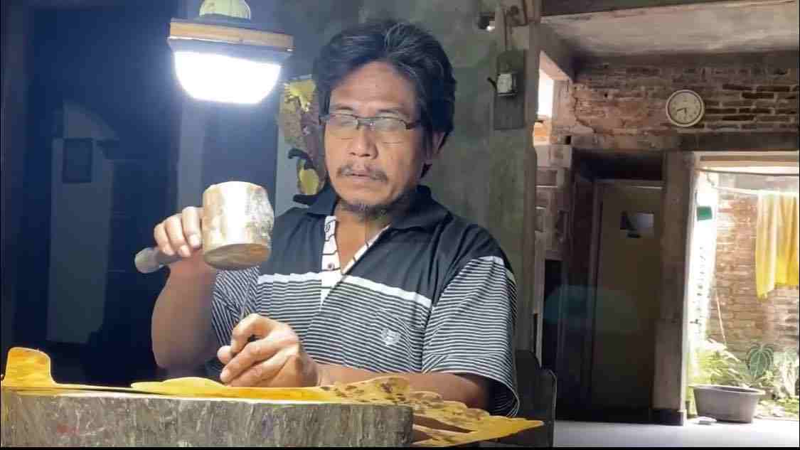 Pengrajin Wayang Kulit Blitar Manfaatkan Live Streaming TikTok untuk Edukasi dan Pemasaran Adi Purwanto saat Memahat Kulit Sapi untuk Membuat Wayang Kulit
