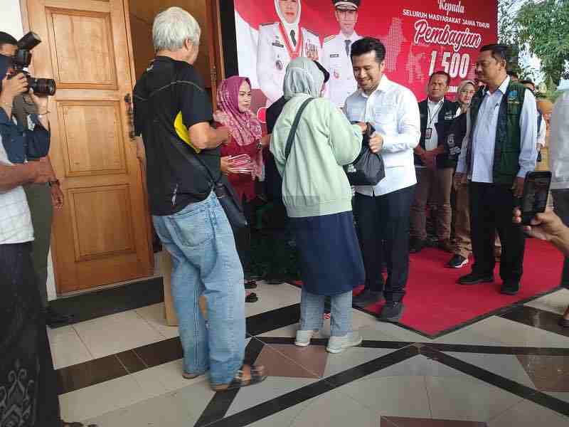 Wakil Gubernur Jawa Timur Emil Elestianto Dardak menyerahkan secara simbolis sembako dan bendera kepada warga