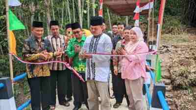 Ketua DPRD Kabupaten Purworejo Tunaryo didampingi Kepala Desa Kedungpomahan Kulon Yusuf dan Ketua BPD Arsyad Wiyanto serta warga saat melakukan pemotongan pita peresmian jembatan