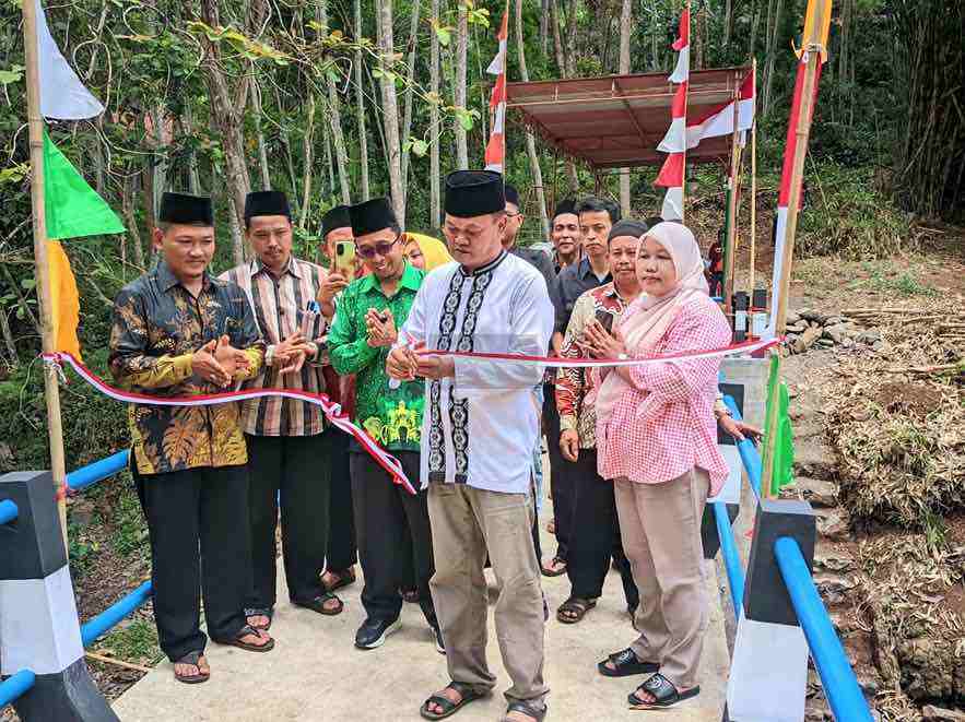 Ketua DPRD Kabupaten Purworejo Tunaryo didampingi Kepala Desa Kedungpomahan Kulon Yusuf dan Ketua BPD Arsyad Wiyanto serta warga saat melakukan pemotongan pita peresmian jembatan