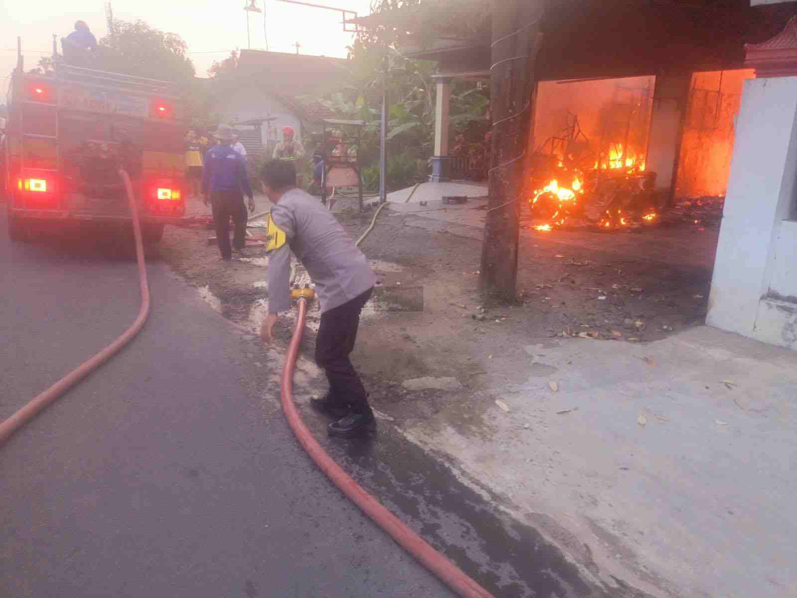 Petugas Memadamkan Api yang Membakat Bengkel Motor di Talun Blitar