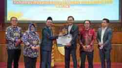 Dekan Fakultas Hukum Unnes Ali Masyhar Menyerahkan Penghargaan kepada Alumni Advokat Ady Putra Cesario