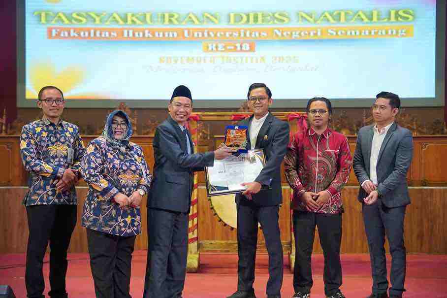 Dekan Fakultas Hukum Unnes Ali Masyhar Menyerahkan Penghargaan kepada Alumni Advokat Ady Putra Cesario