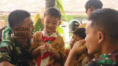 Anggota TNI dari Kodim 0809 saat Bersama Siswa Siswi MI Kecamatan Puncu Kabupaten Kediri di acara TMMD