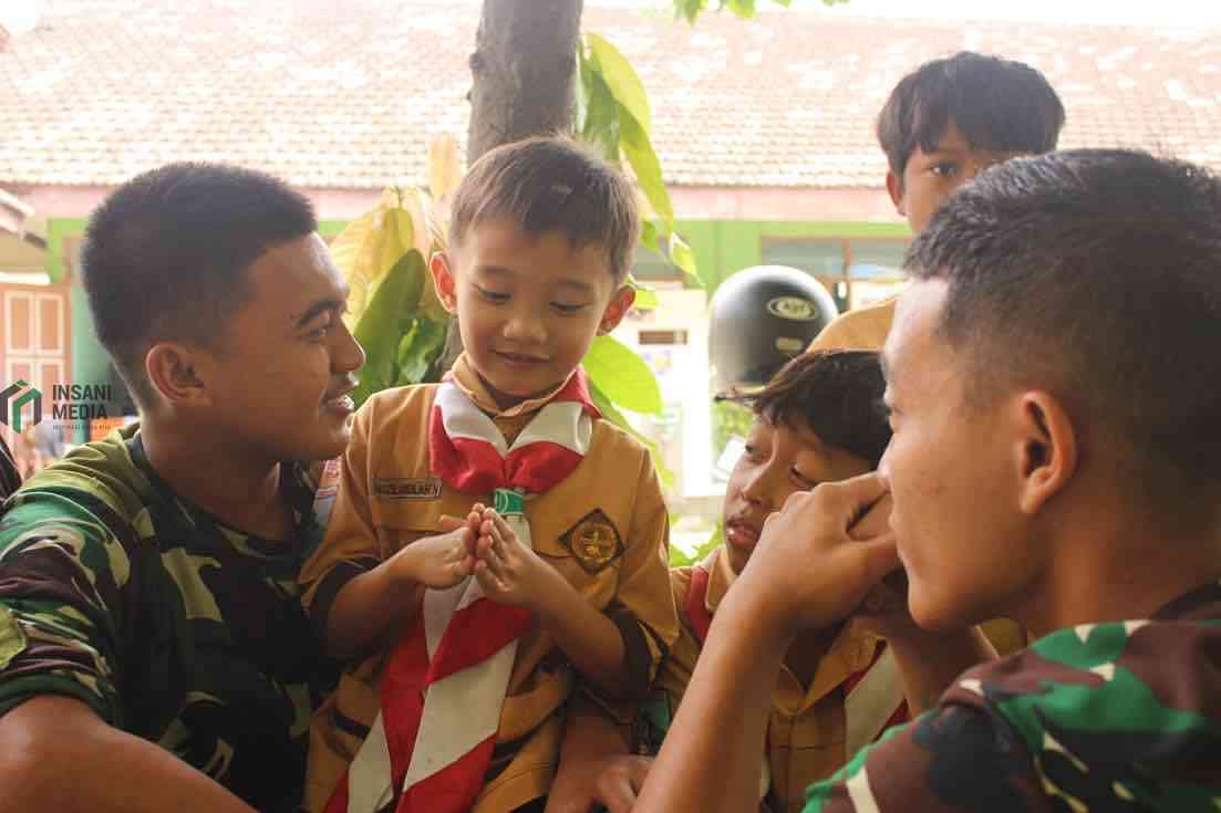 Anggota TNI dari Kodim 0809 saat Bersama Siswa Siswi MI Kecamatan Puncu Kabupaten Kediri di acara TMMD