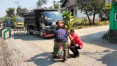 Warga Desa Karangrejo Kecamatan Garum Kabupaten Blitar menanam pohon pisang di tengah ruas jalan yang rusak