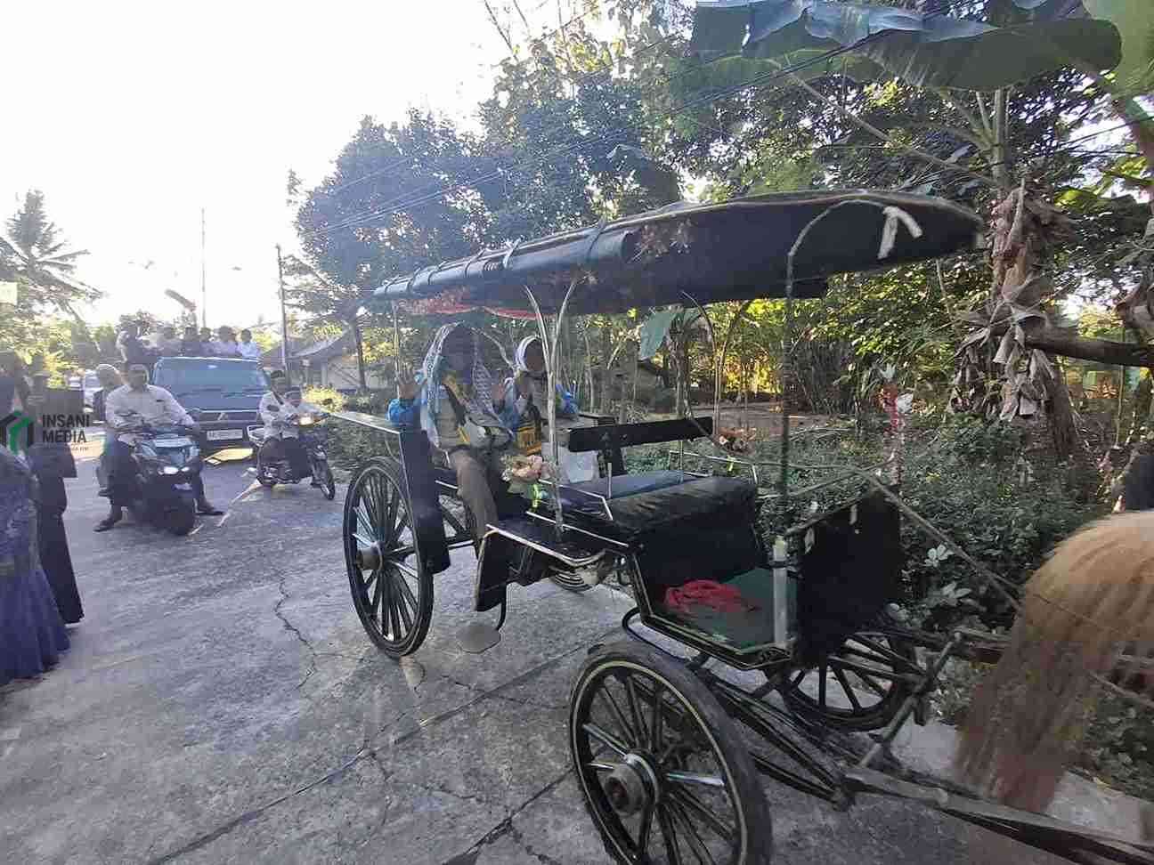 Pulang Haji, Pasangan Guru di Purworejo Diarak Naik Kereta Kuda Warga Kampung Cangkrepkidul Kecamatan Purworejo Kabupaten Purworejo menyambut kepulangan pasangan suami istri jamaah haji Drs. H. Iswahyudi dan Hj. Ani Saadah dengan arak arakan kereta kuda