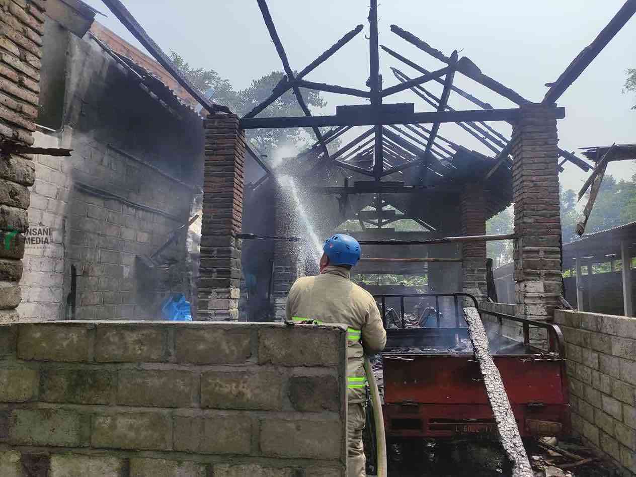 Petugas Pemadam Kebakaran Memadamkan Api yang Membakar Gedung Pakan Bebek di Ponggok Kabupaten Blitar