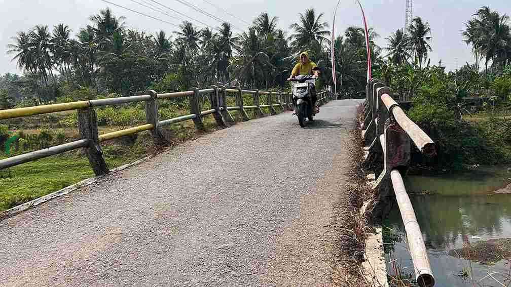 Seorang Warga Melintasi Jembatan Sirnoboyo di Kecamatan Bonorowo Kabupaten Kebumen yang Kondisinya Mulai Rusak
